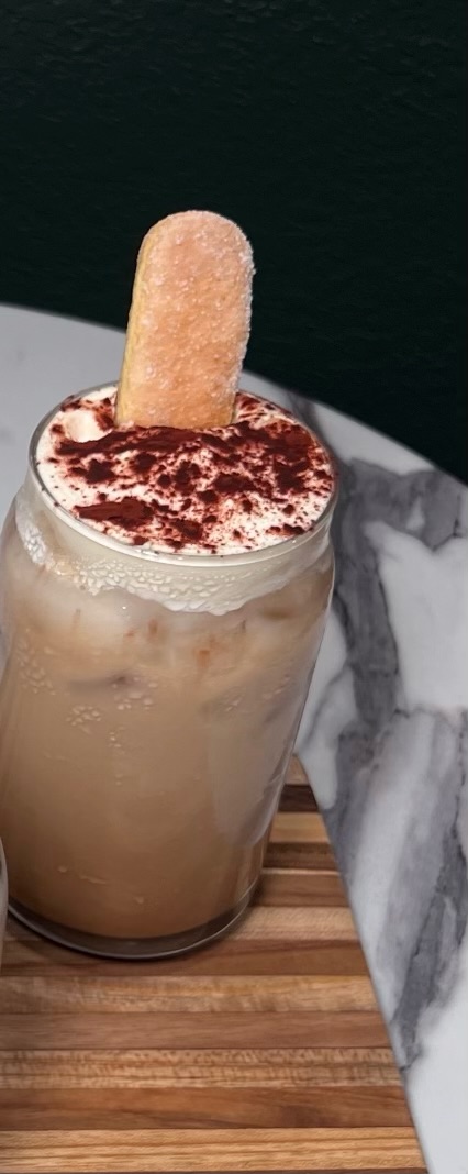 Iced cocoa tiramisu latte with foam and ladyfinger